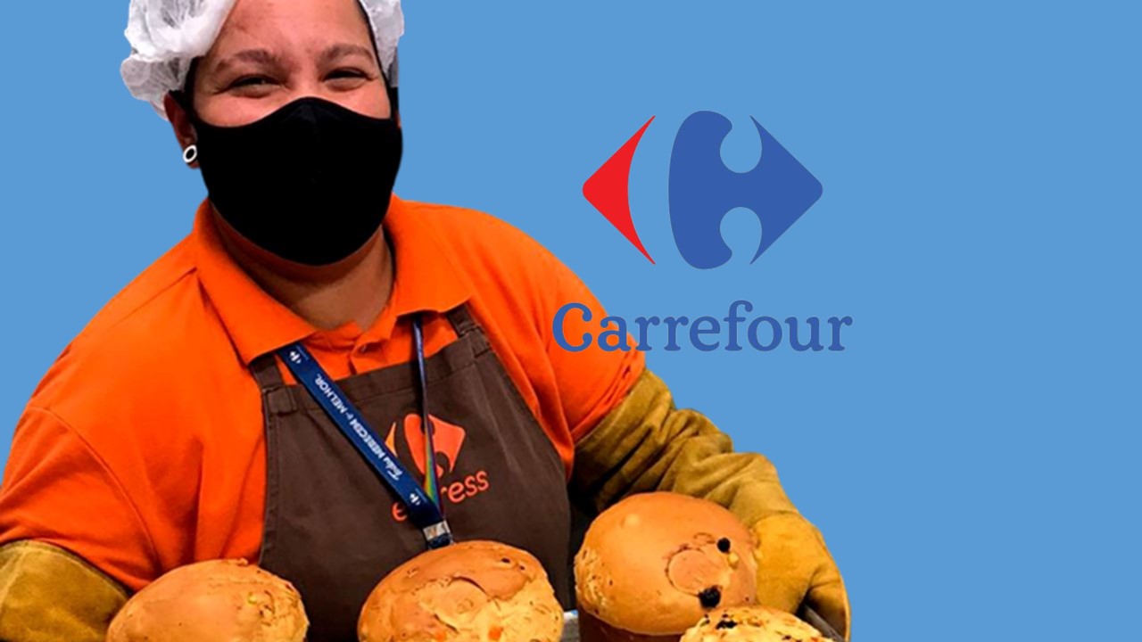 Mulher com fornada de panetone sorrindo e logo Carrefour ao lado